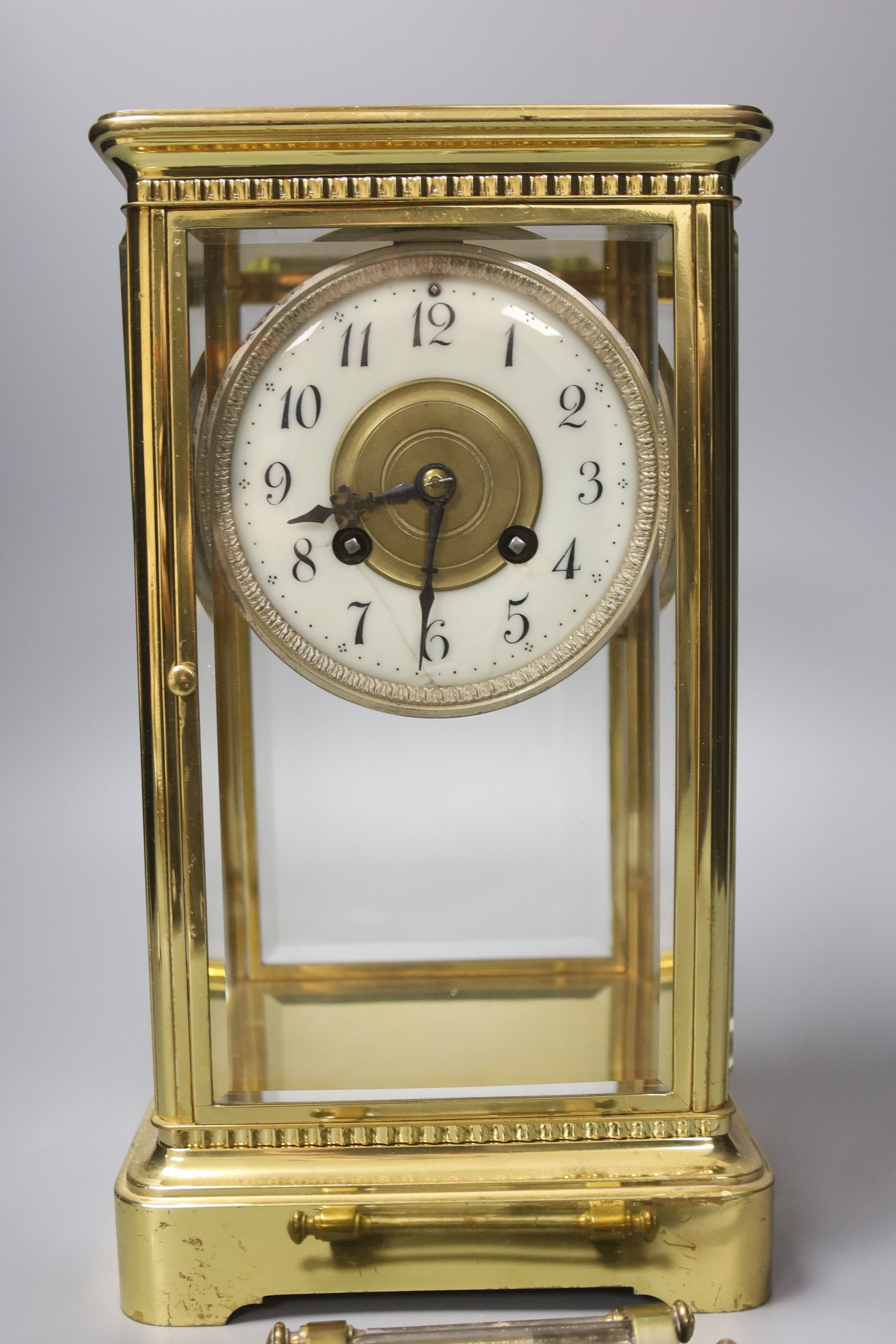 A French brass four glass clock, key and pendulum 27cm